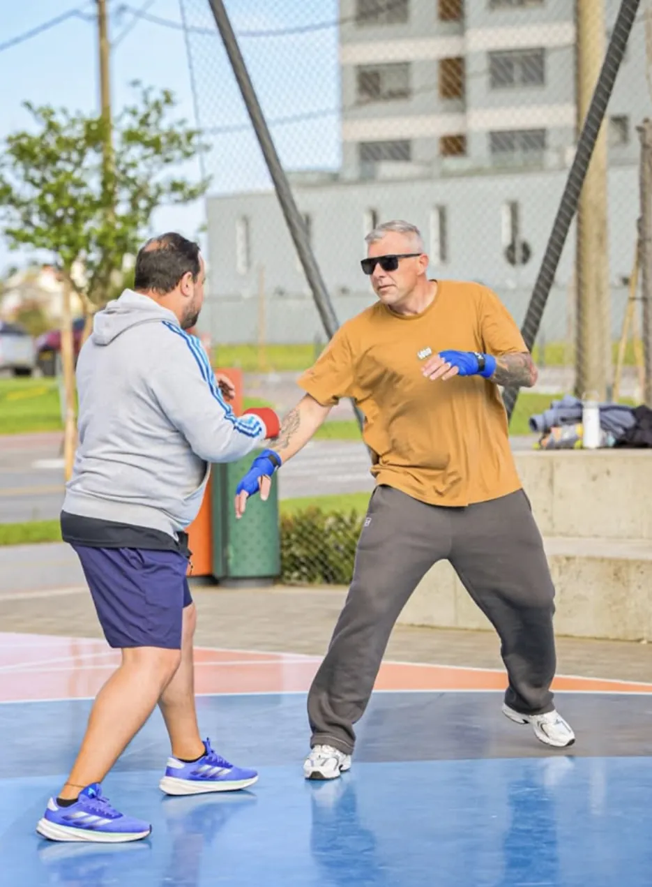 Professor orientando aluno em treino ao ar livre